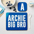 Blue placemat with 'ARCHIE BIG BRO' text on a table with breakfast items