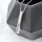 Silver necklace with 'papa bear' pendant on a gray geometric object