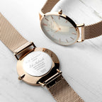 Rose gold watch with mesh band on a light background
