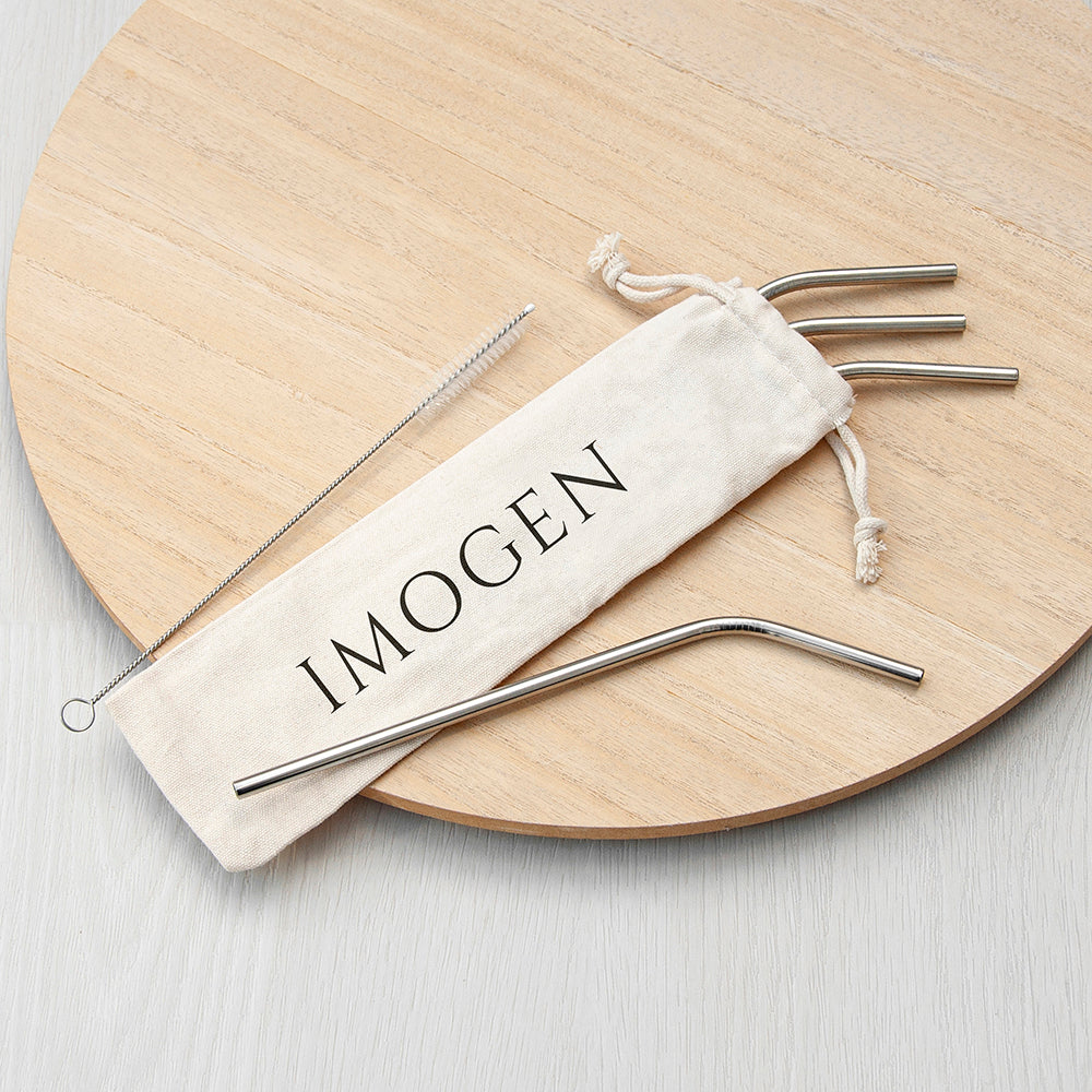 Metal straws in a branded pouch on a wooden board