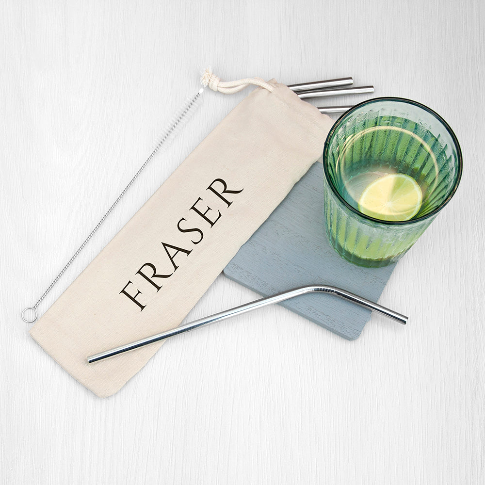 Metal straws with a branded pouch and a green glass on a white background