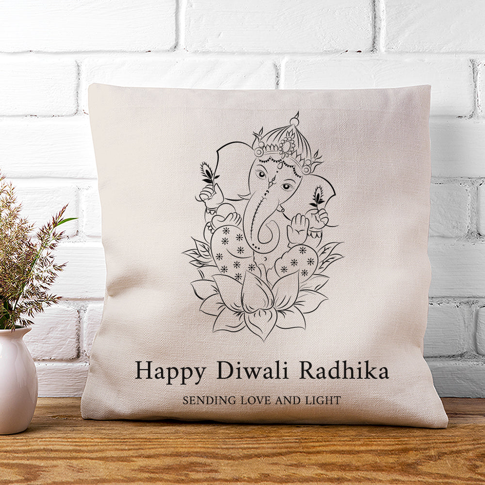 Decorative pillow with Ganesha design and text on a white brick wall background