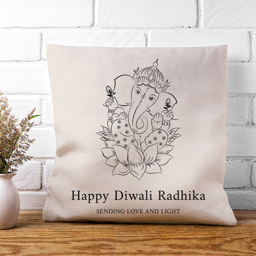 Decorative pillow with Ganesha design and text on a white brick wall background