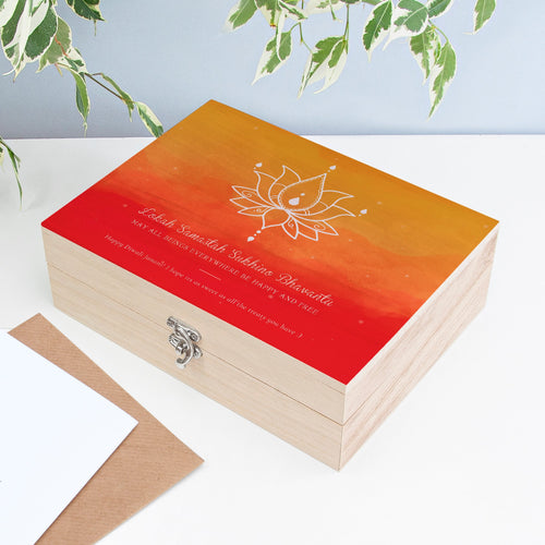 Wooden box with red and orange gradient lid featuring a white lotus design and text.