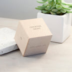 Hexagonal wooden box with 'Cocktail Night' text on a light surface with a plant in the background