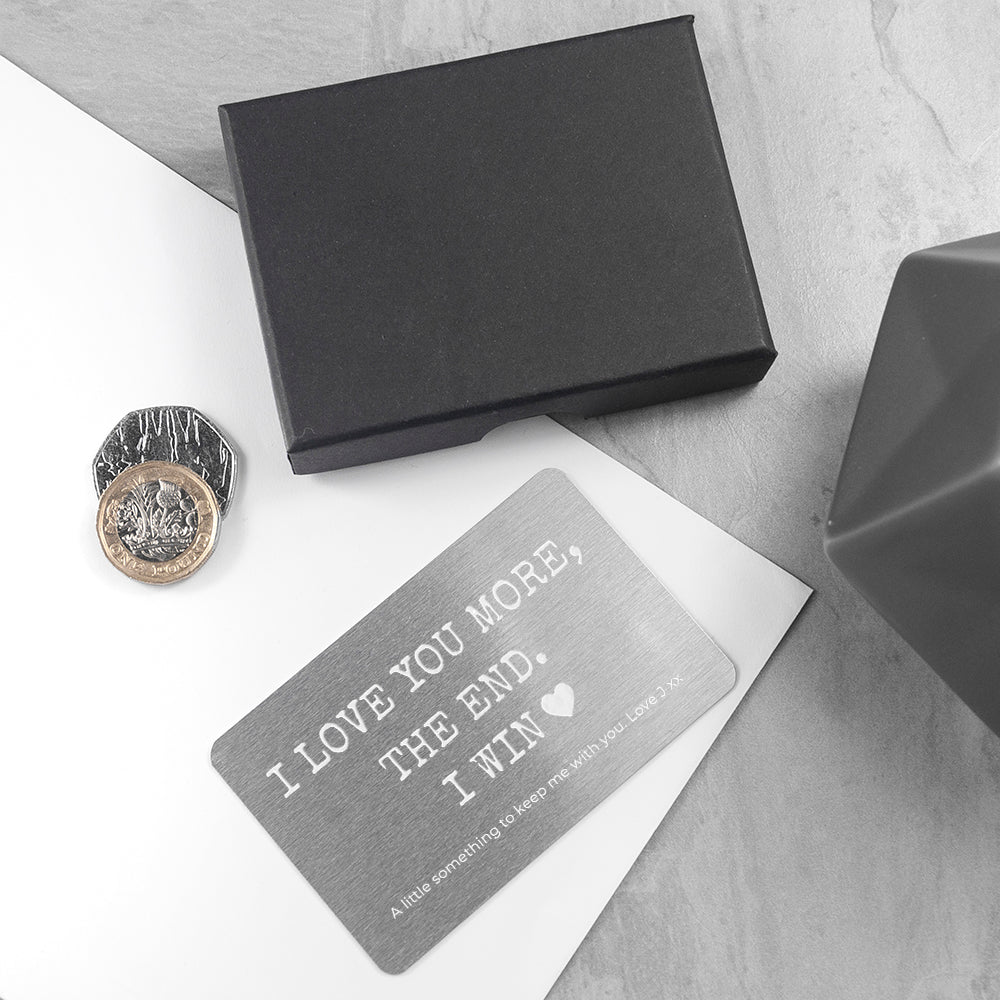 Black box, coin, and card with humorous text on a light gray surface