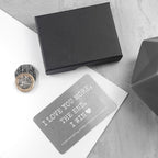 Black box, coin, and card with humorous text on a light gray surface