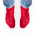 Red socks with giraffe illustrations and names 'Olivia' and 'Kate' on a white background.