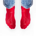 Red socks with giraffe designs and names 'Claire' and 'Chris' on a white background.