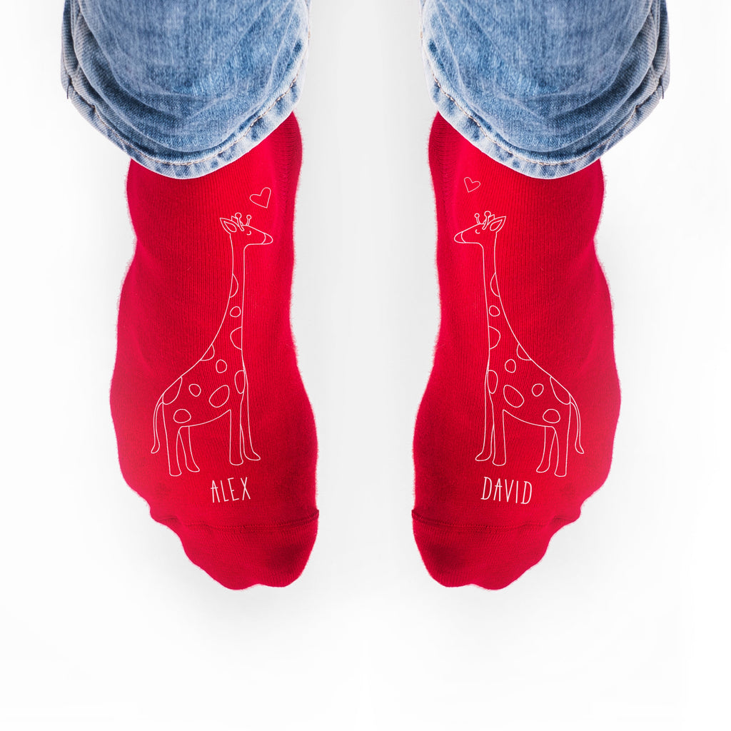 Red socks with giraffe designs and names 'Alex' and 'David' on a white background.