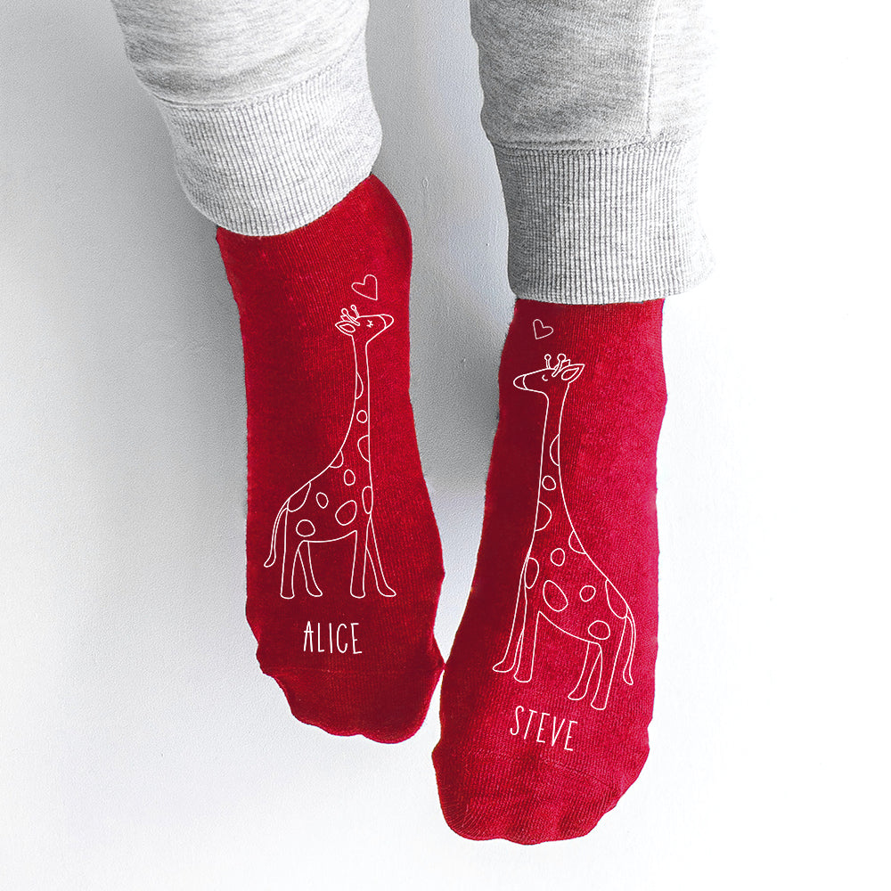 Red socks with giraffe designs and names 'Alice' and 'Steve' on a white background
