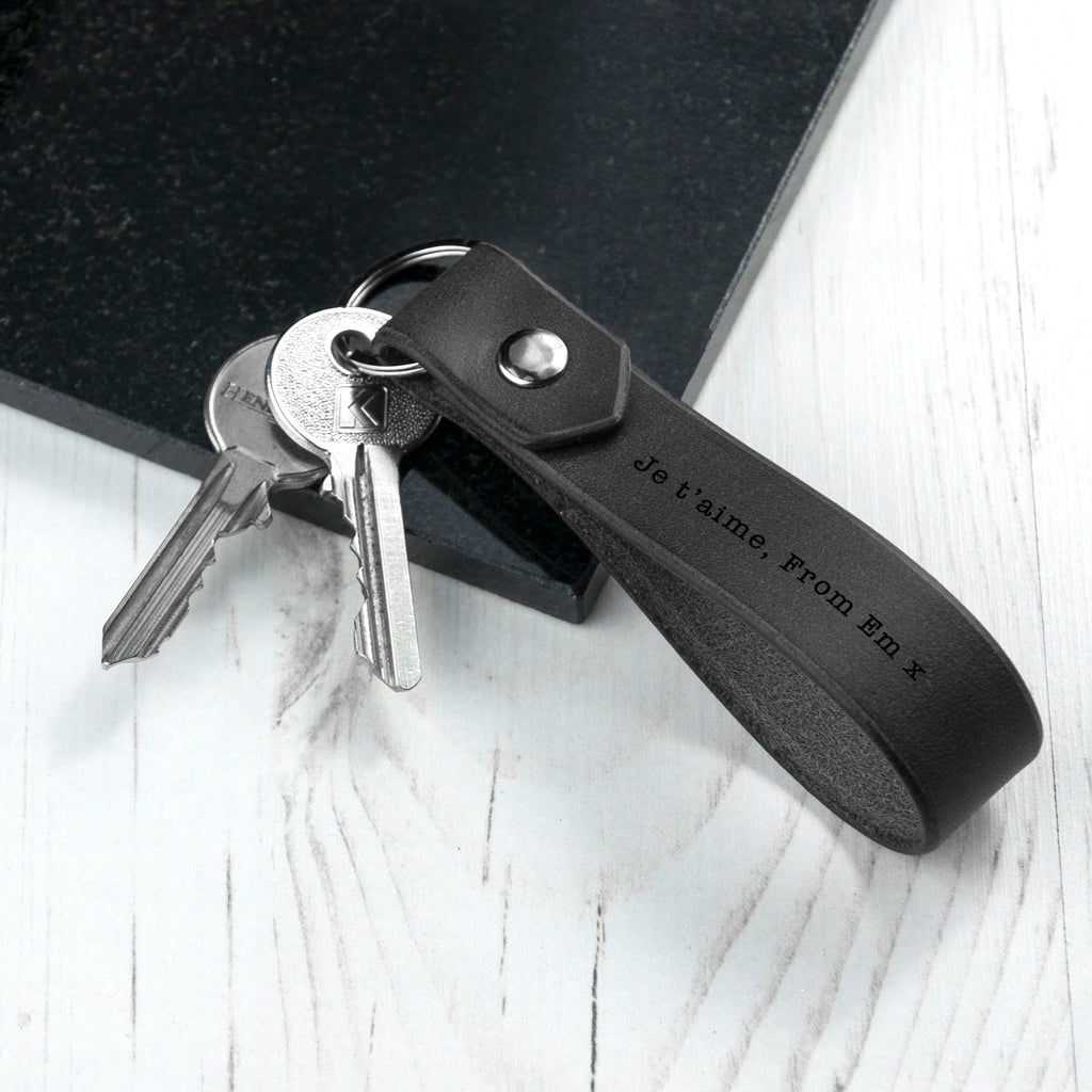 Black leather key fob with keys on a white surface