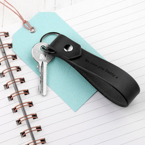 Black keychain with keys on a light blue tag over a notebook