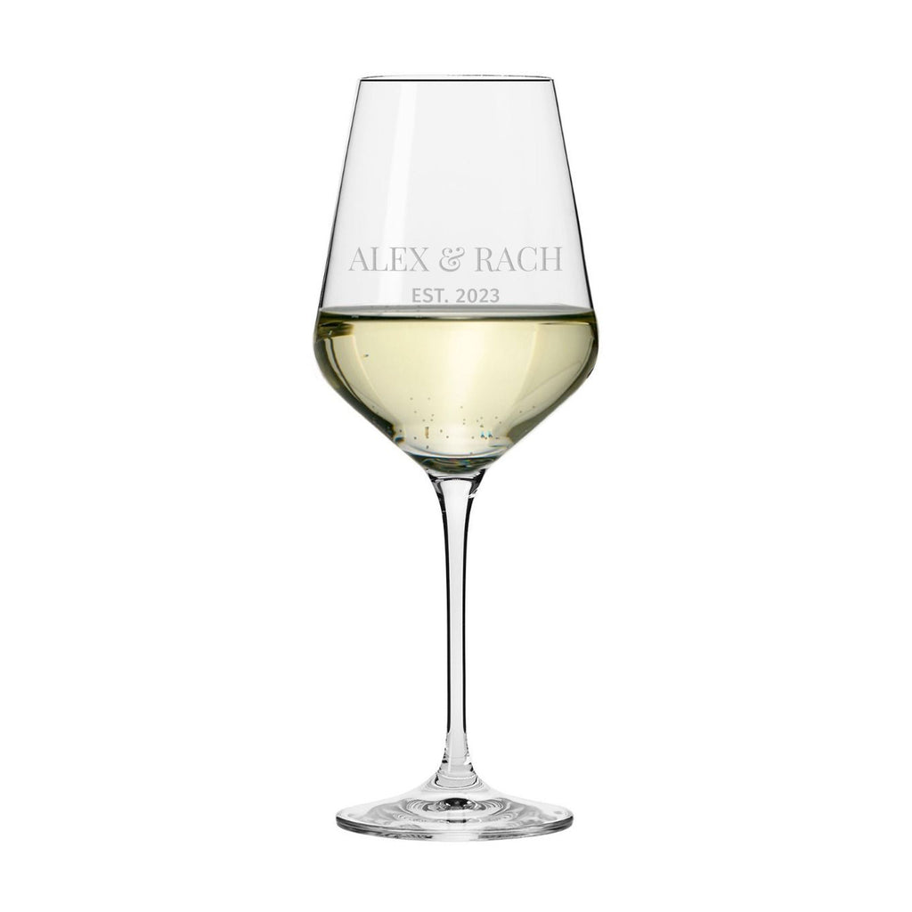 Wine glass with white wine and engraved text on a white background