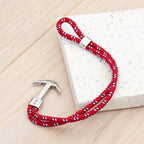 Red braided bracelet with silver clasp on a light wooden surface