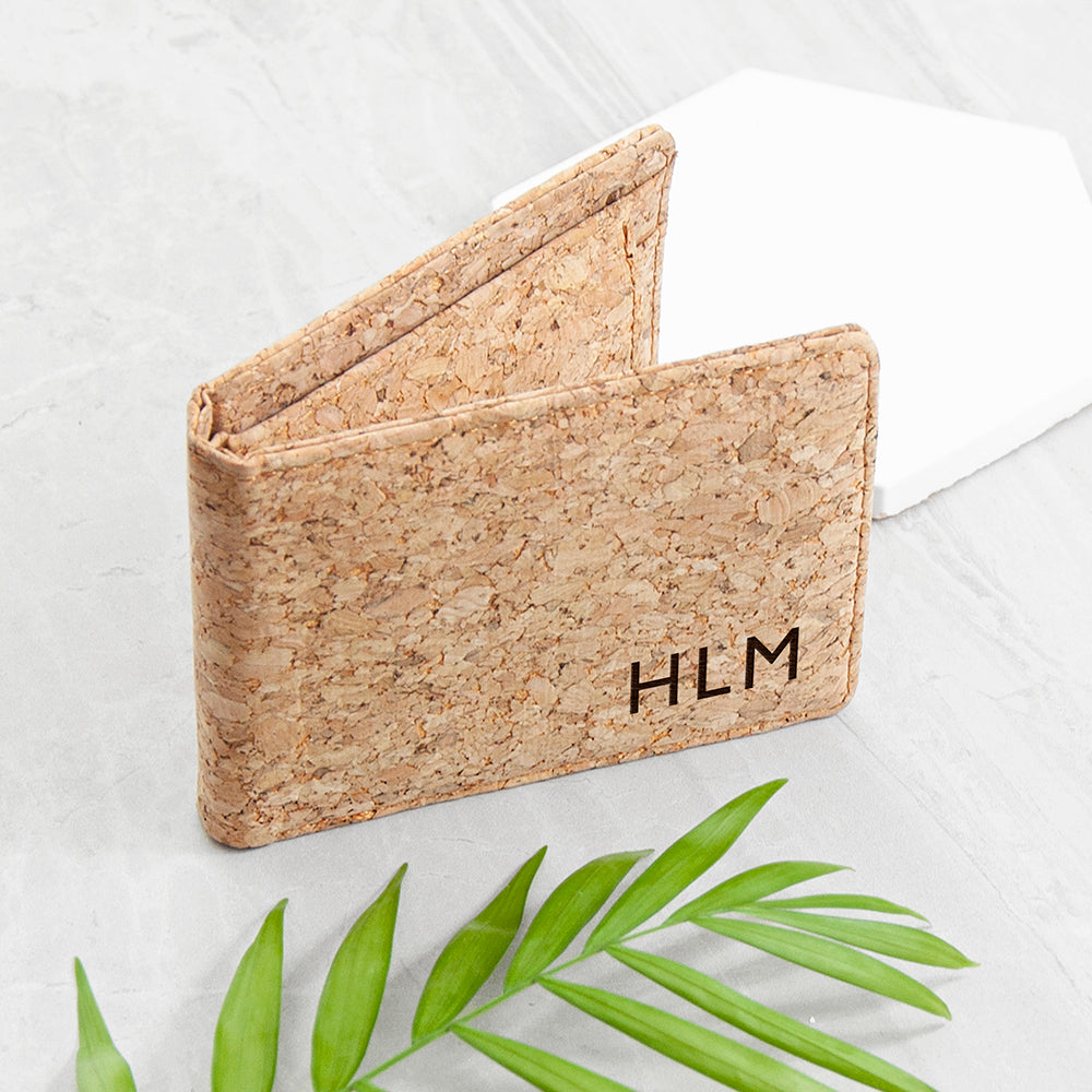 Cork wallet with 'HLM' initials on a light background with green leaves.