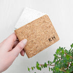 Cork wallet with initials 'KH' held by a hand on a light background