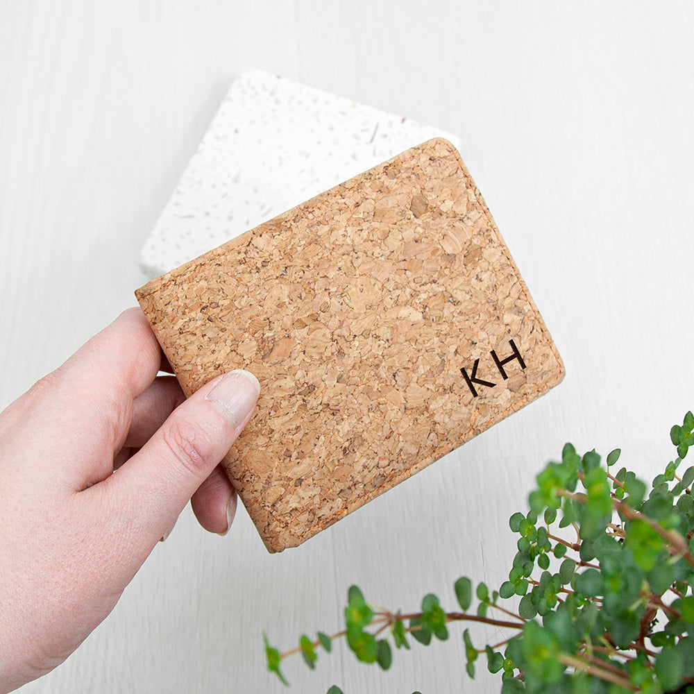 Cork wallet with initials 'KH' held by a hand on a light background