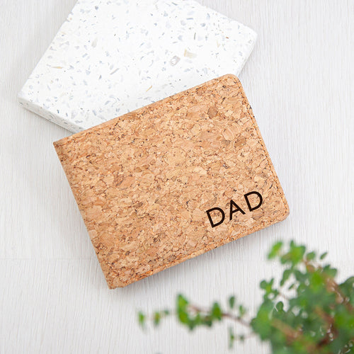 Cork cardholder with 'DAD' engraving on a light wooden surface