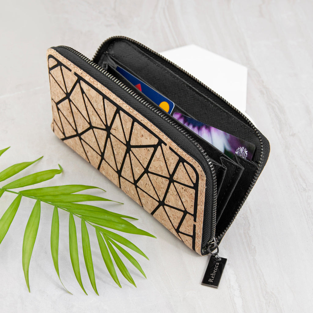 Cork wallet with geometric design on a white background with a green leaf