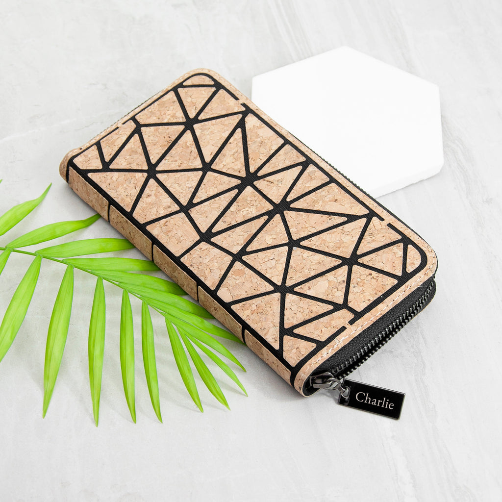 Cork wallet with geometric pattern on a white background with green leaves