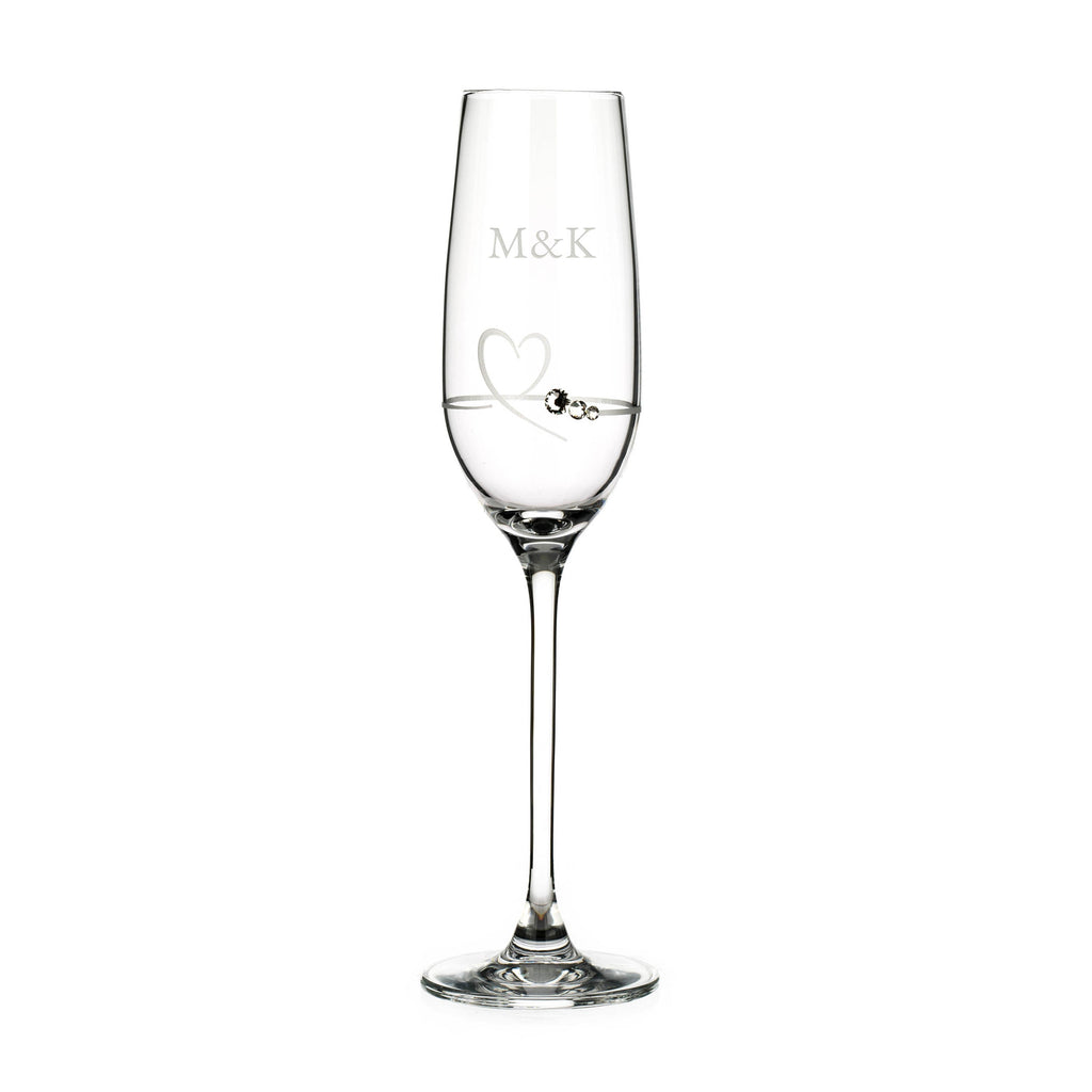 Clear champagne flute with 'M&K' engraving on a white background