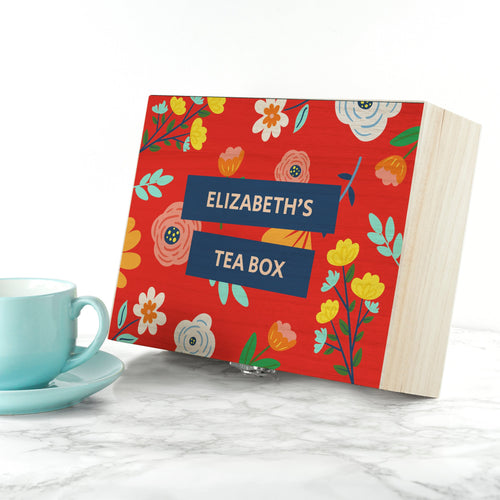 Floral-patterned tea box with 'Elizabeth's Tea Box' text next to a turquoise mug on a white surface.