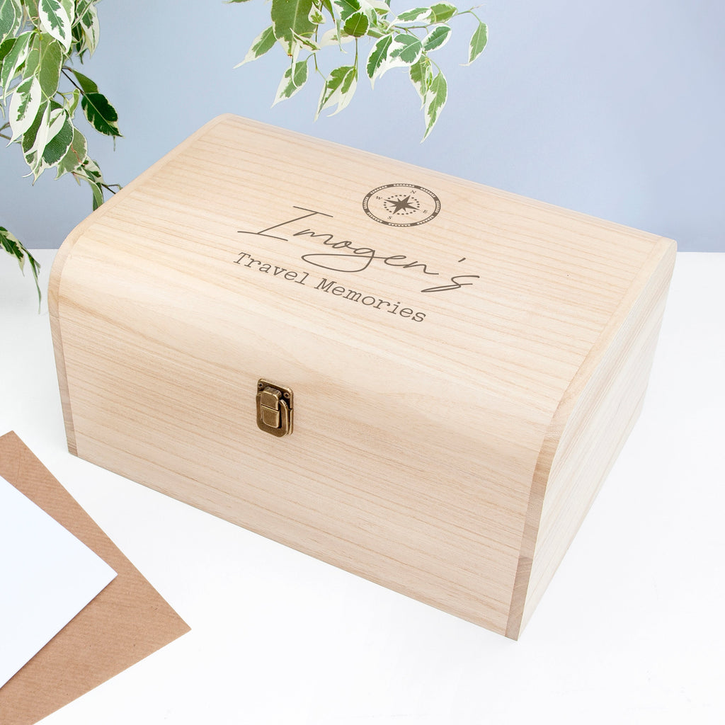 Wooden box with 'Imogen's Travel Memories' engraving on a light blue background