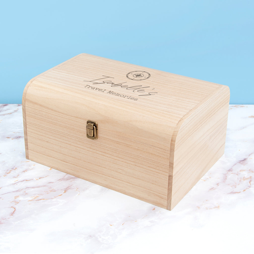 Wooden box with engraved text on a marble surface with a light blue background