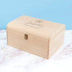 Wooden box with engraved text on a marble surface with a light blue background