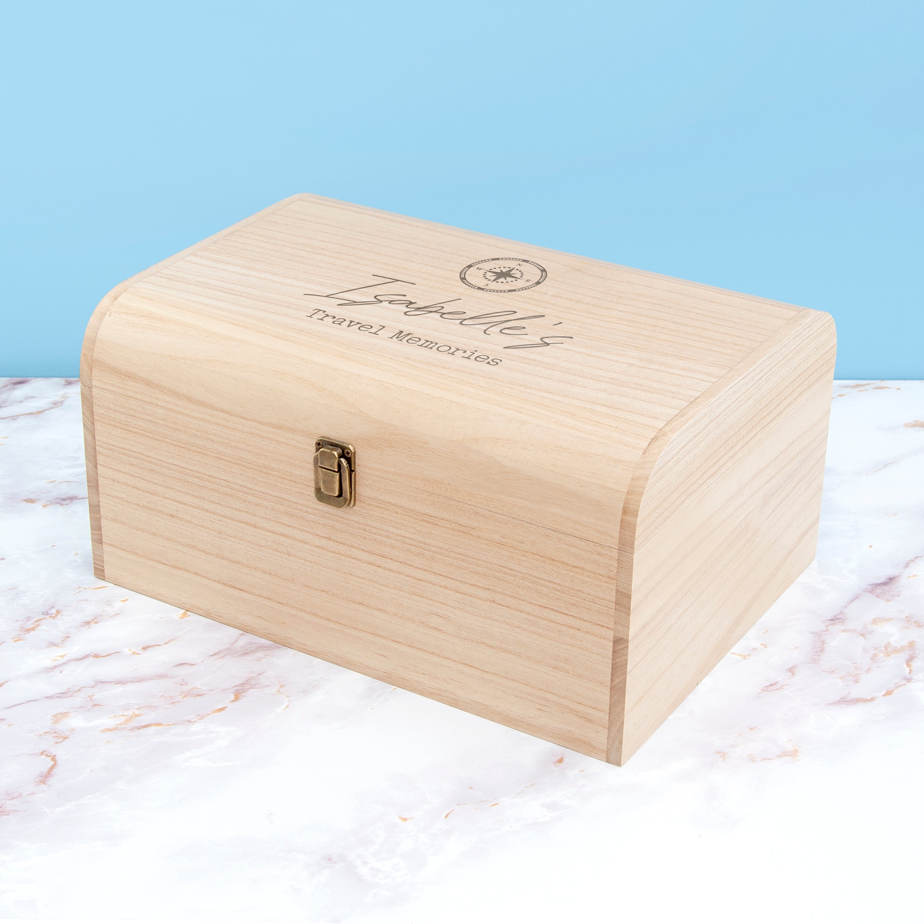 Wooden box with engraved text on a marble surface with a light blue background