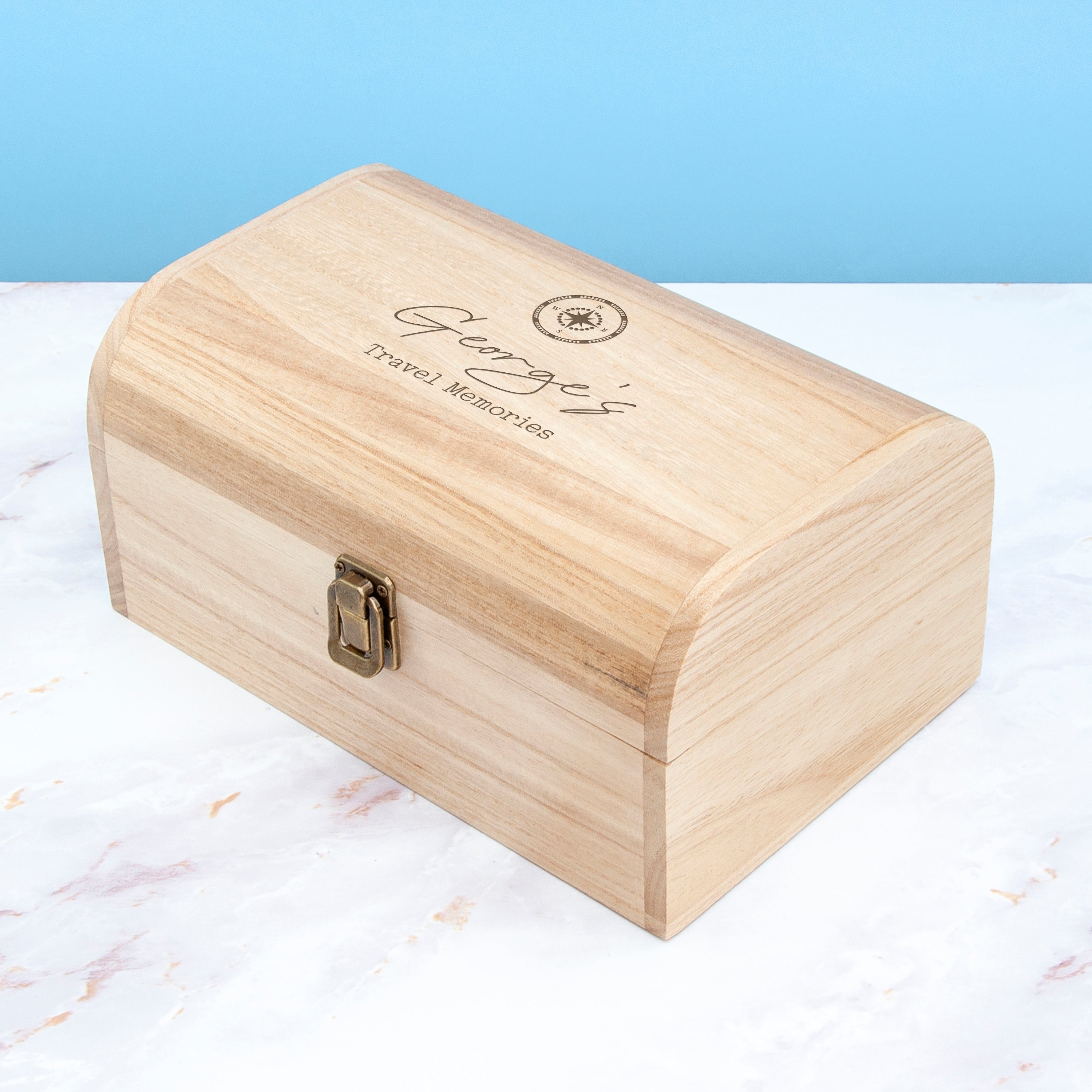 Wooden box with engraved text on a marble surface