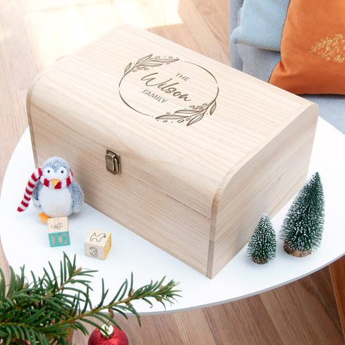 Wooden box with engraved text on a table with Christmas decorations