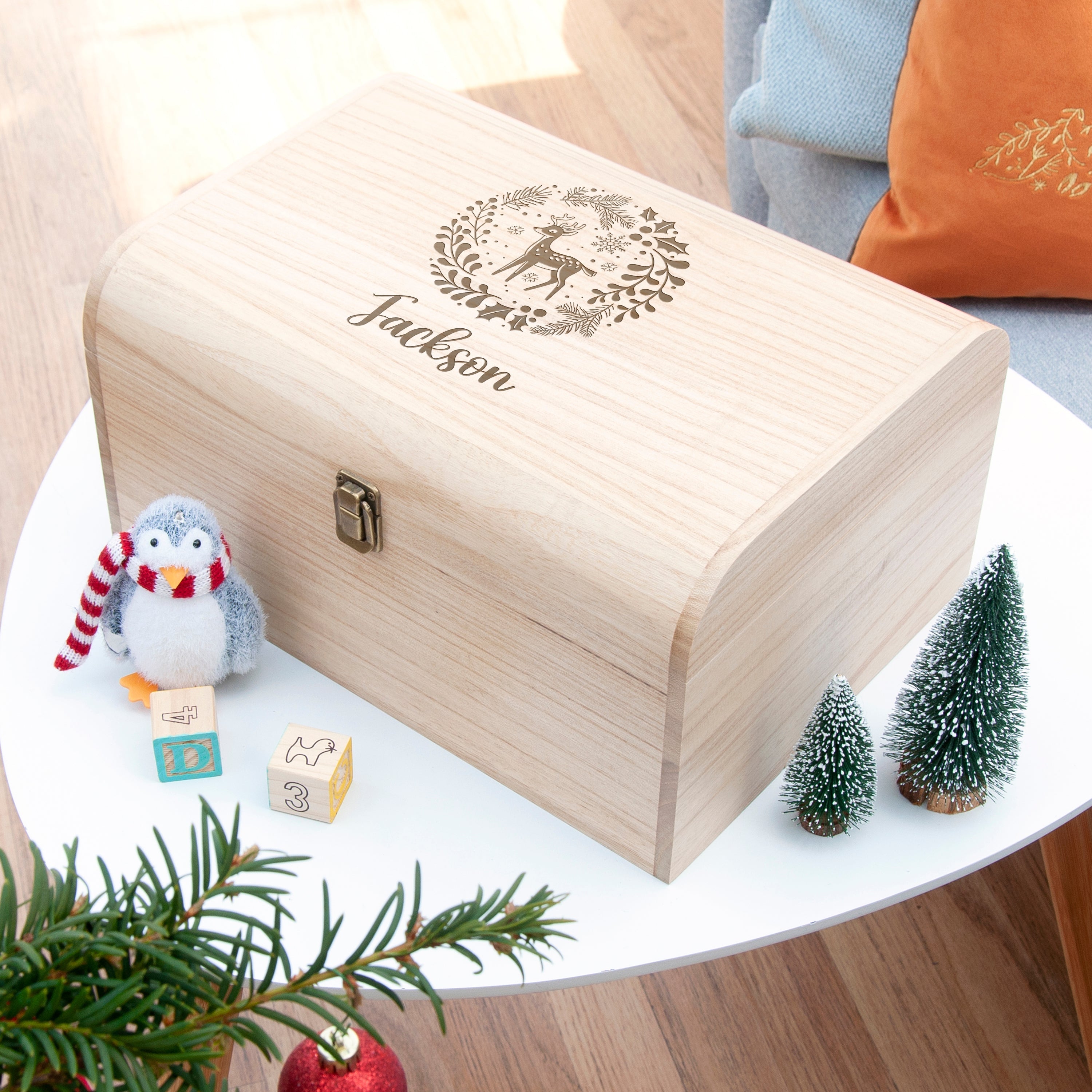 Wooden box with 'Jackson' engraving on a table with decorative items