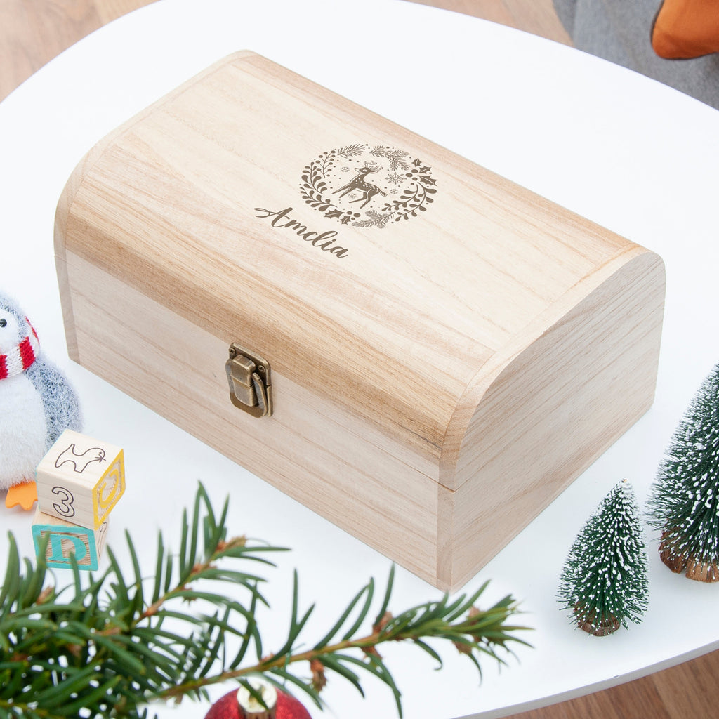 Wooden box with engraved design and text on a white surface with decorative elements.