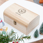 Wooden box with engraved design and text on a white surface with decorative elements.