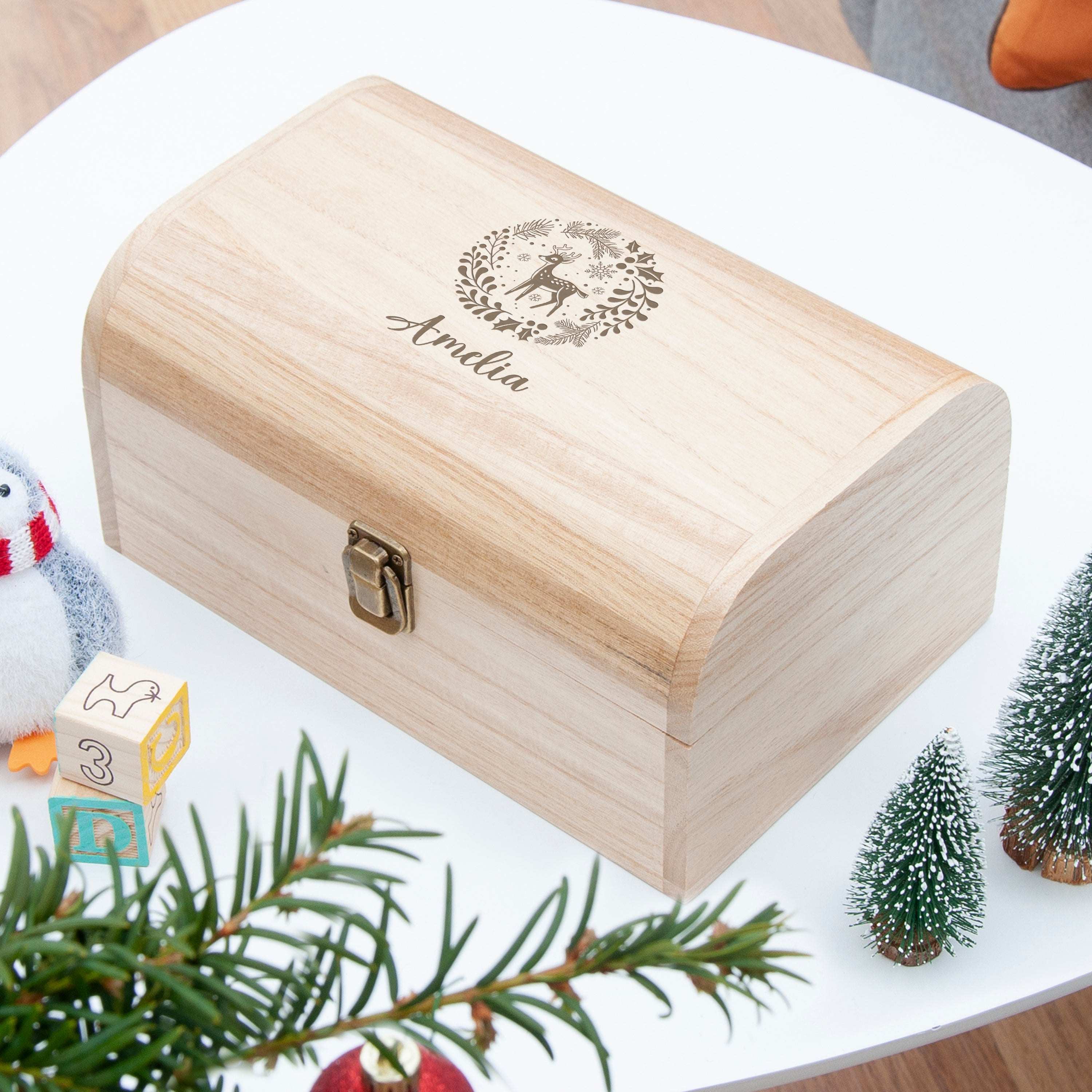 Wooden box with engraved design and text on a white surface with decorative elements.