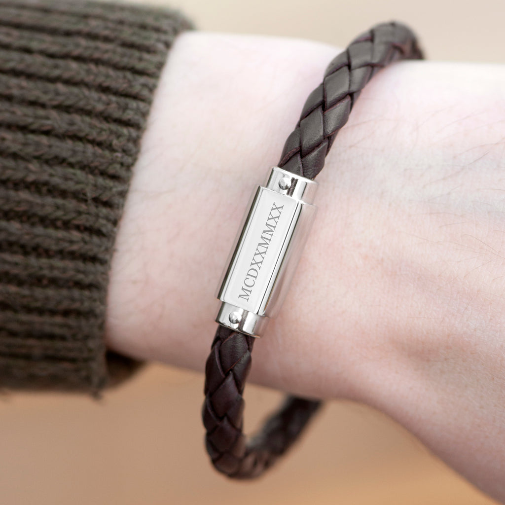 Brown braided bracelet with a silver tag on a wrist, brand 'FRASER' visible
