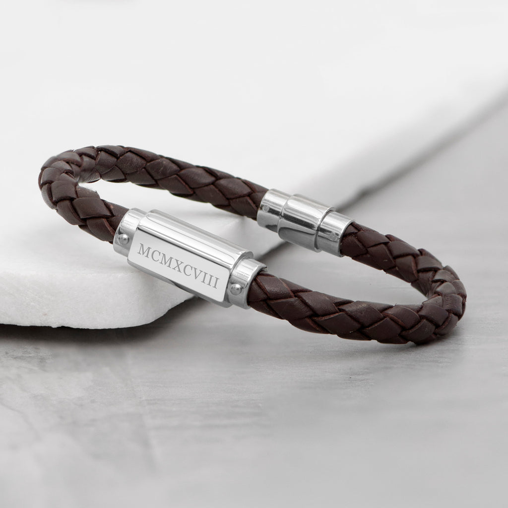 Brown braided leather bracelet with silver clasp on a light gray background