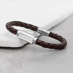 Brown braided leather bracelet with silver clasp on a light gray background