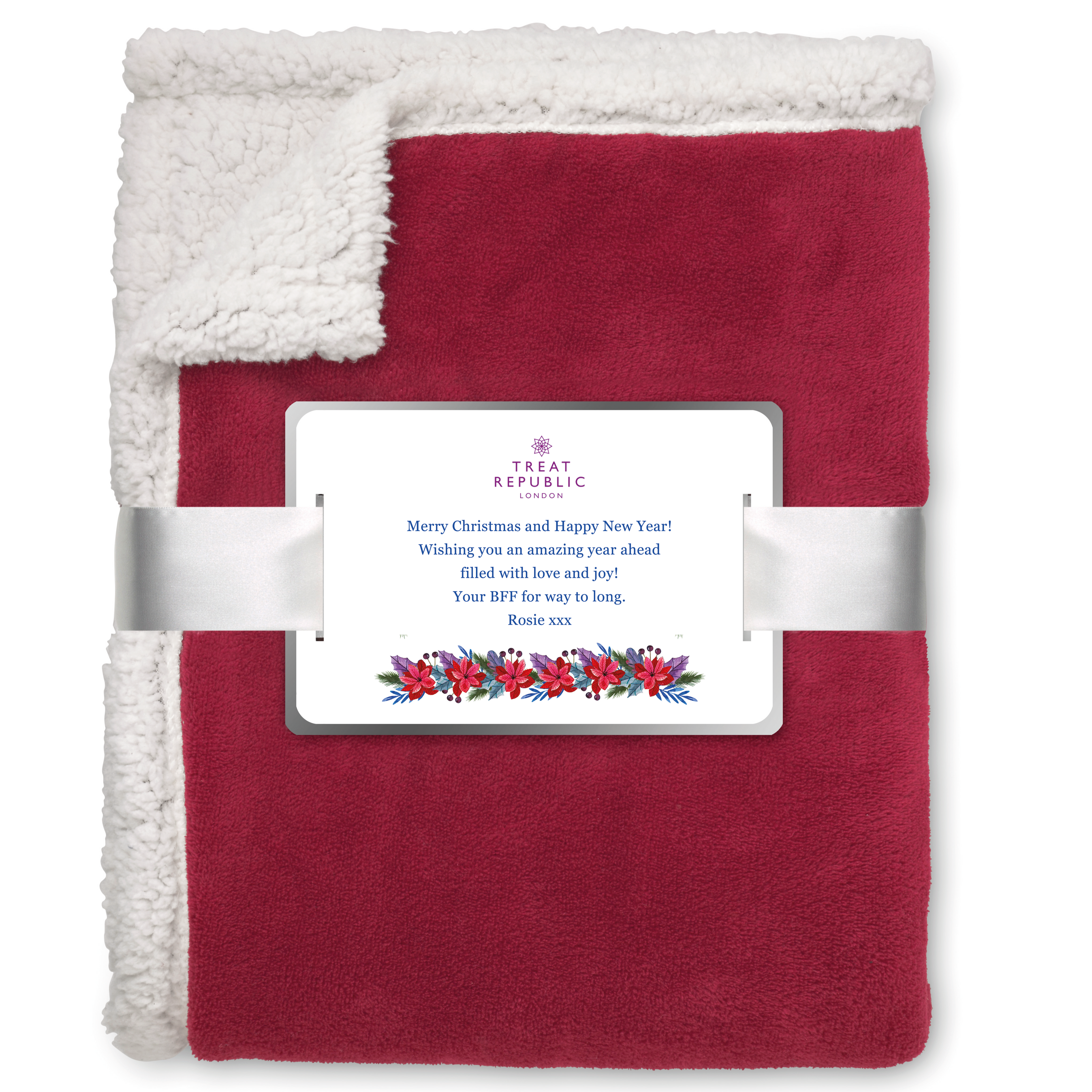 Red blanket with white sherpa lining and a decorative card on a white background