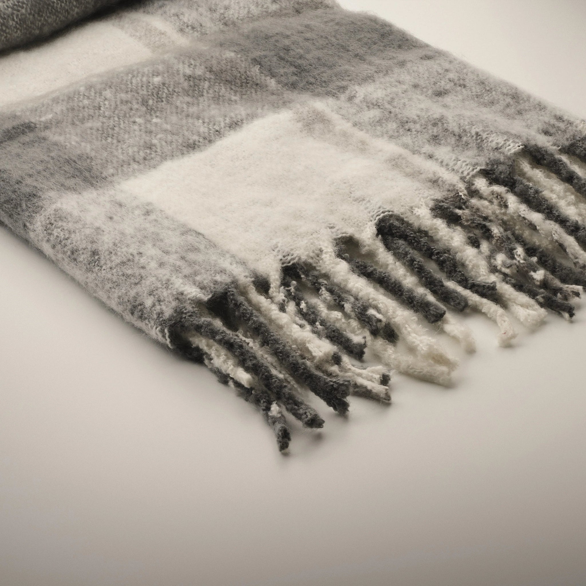 Plaid scarf with fringe on a light background