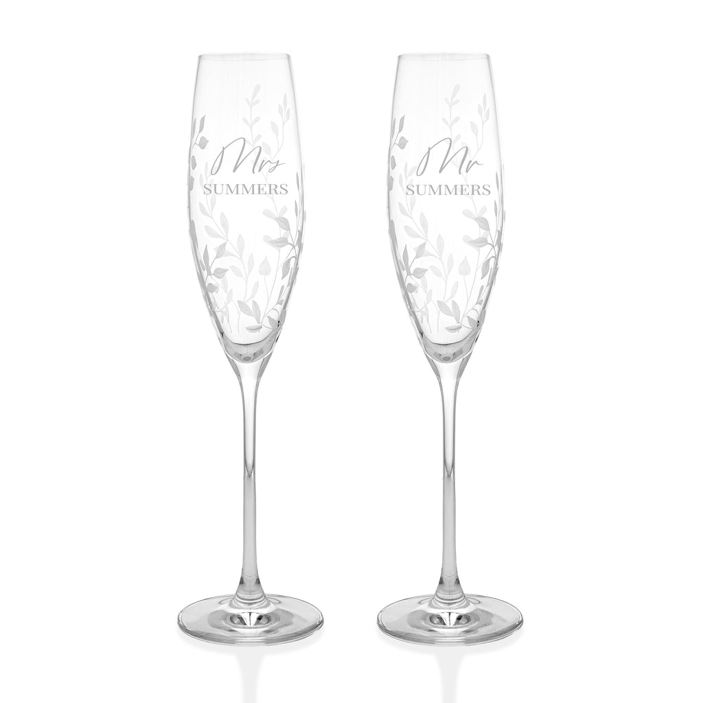Two crystal champagne flutes with 'Mr' and 'Mrs' inscriptions on a white background