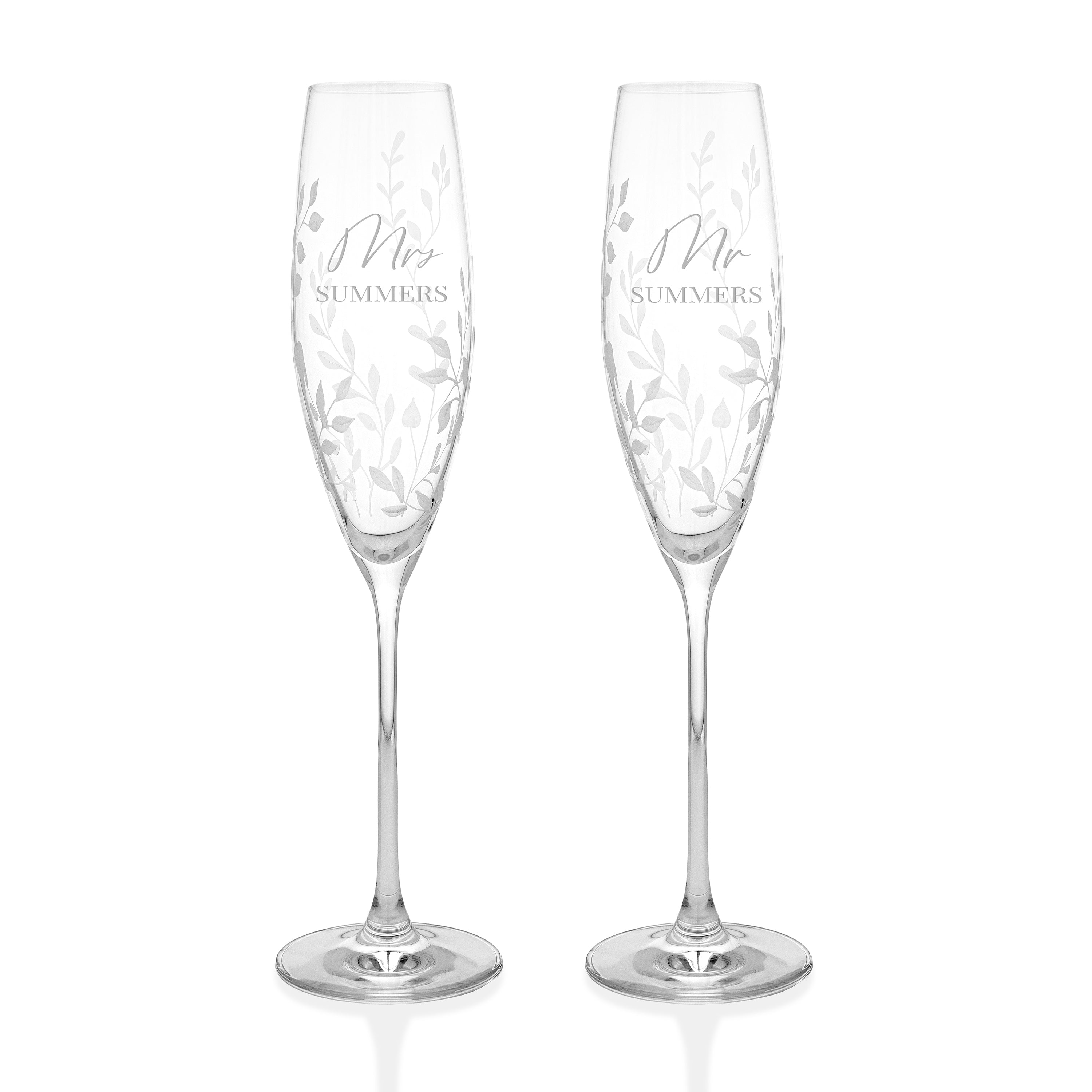Two crystal champagne flutes with 'Mr' and 'Mrs' inscriptions on a white background