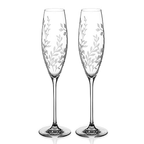 Two elegant champagne flutes with leaf patterns on a white background