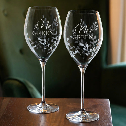 Two etched wine glasses with 'Mr Green' and 'Mrs Green' text on a wooden surface.