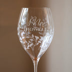 Wine glass with 'Mrs. Howell' engraving on a plain background