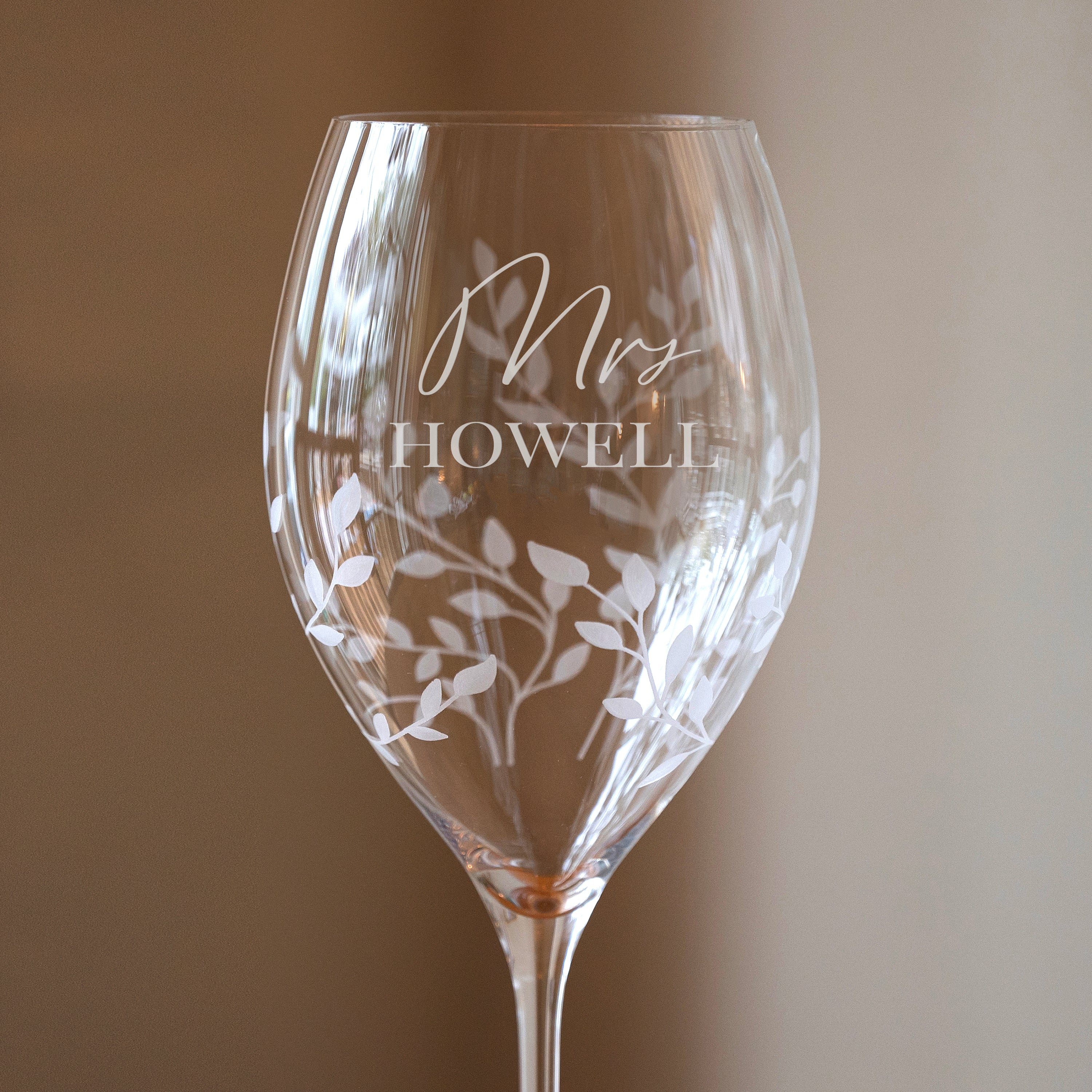 Wine glass with 'Mrs. Howell' engraving on a plain background