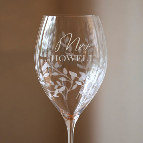 Wine glass with 'Mrs. Howell' engraving on a plain background