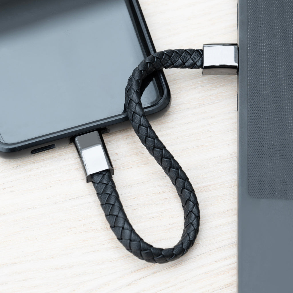 Black braided USB cable with 'LG' and 'Lucis' branding on a light wooden surface.